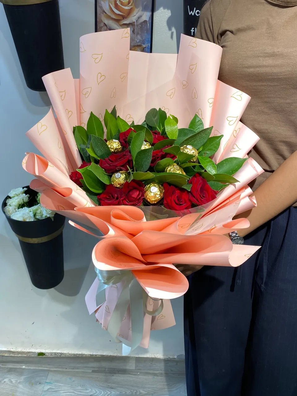 Amour & Chocolat – Bouquet rouge gourmand, vue rapprochée, fleurs rouges fraîches, feuillage vert et chocolats