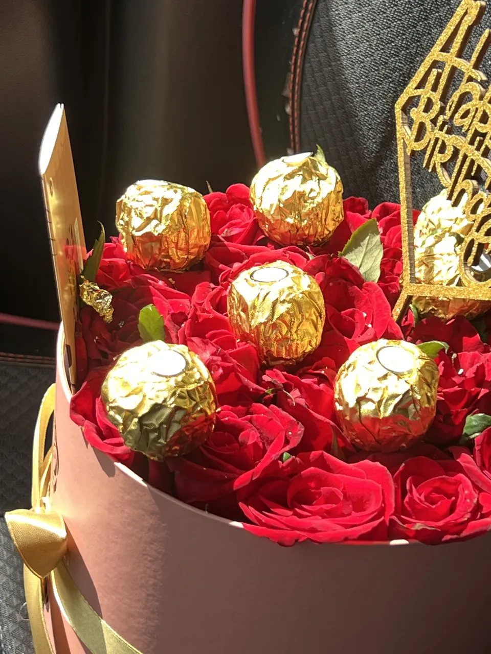 Box Amour & Douceur – Roses rouges & chocolat, vue rapprochée, roses rouges fraîches avec chocolats dans une box ronde
