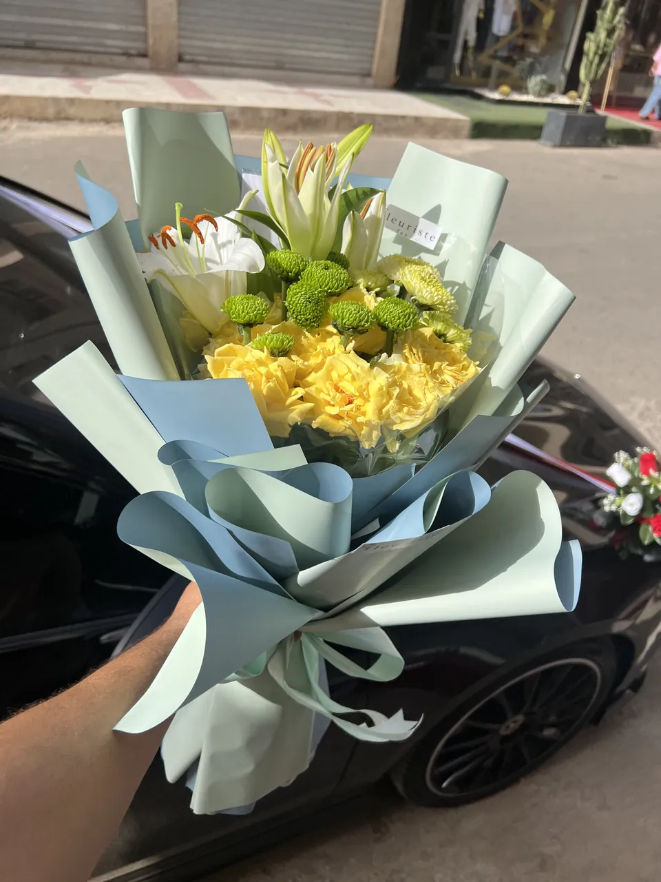 Évasion Aquatique – Bouquet bleu, jaune & blanc, vue rapprochée, lys blancs, roses jaunes et fleurs jaunes et vertes
