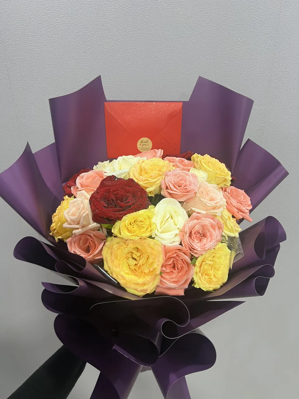 Jardin Coloré – Bouquet multicolore, vue rapprochée, roses et fleurs fraîches variées dans un emballage violet